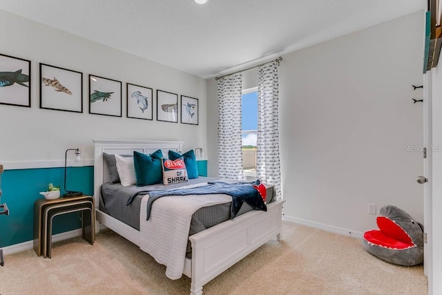 bedroom featuring light colored carpet and baseboards