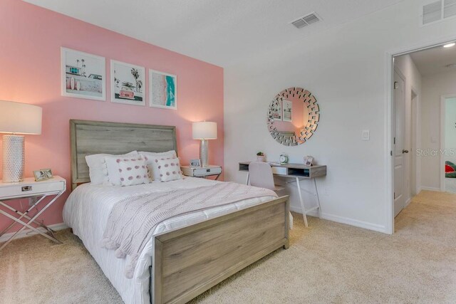 bedroom with light colored carpet, visible vents, and baseboards