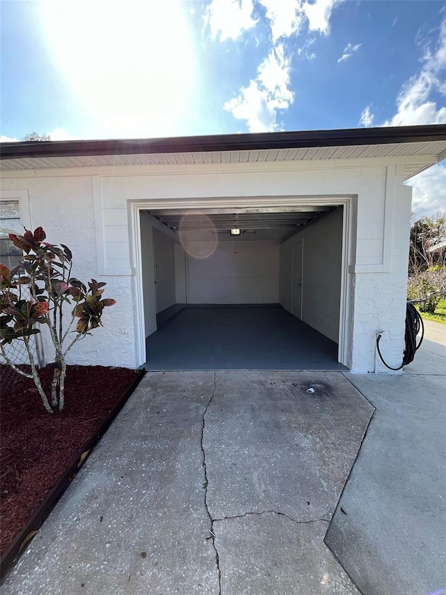 garage featuring concrete driveway