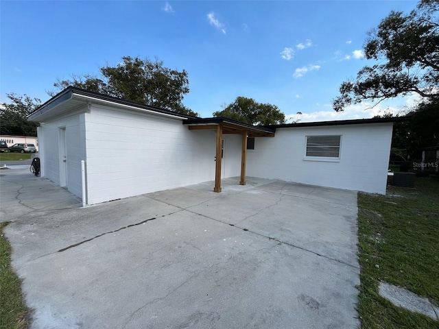 exterior space with a patio area and concrete block siding