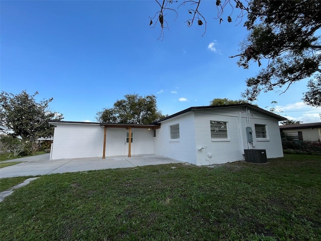 rear view of house featuring a yard, central AC unit, and a patio