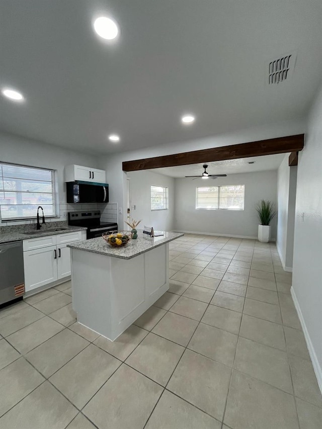 kitchen with light stone counters, light tile patterned flooring, a sink, white cabinets, and appliances with stainless steel finishes