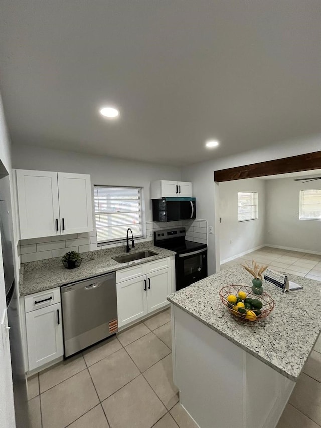 kitchen featuring electric range, stainless steel dishwasher, backsplash, a sink, and black microwave