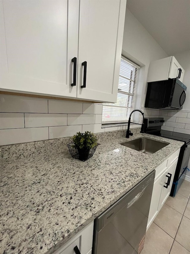 kitchen featuring tasteful backsplash, light stone counters, stainless steel dishwasher, white cabinetry, and a sink