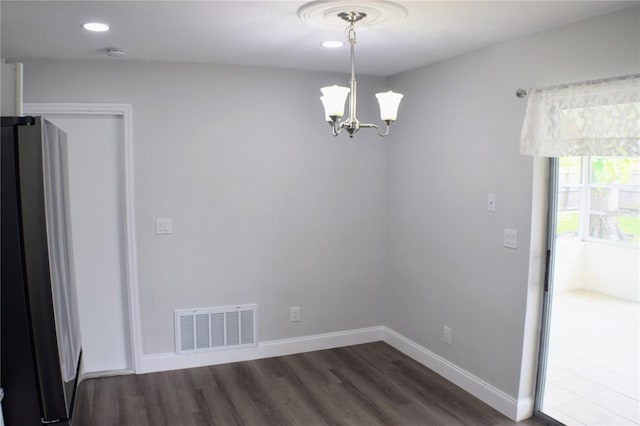 unfurnished room with a notable chandelier, recessed lighting, dark wood-type flooring, visible vents, and baseboards