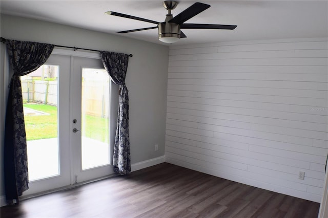 unfurnished room featuring ceiling fan, dark wood finished floors, a wealth of natural light, and french doors