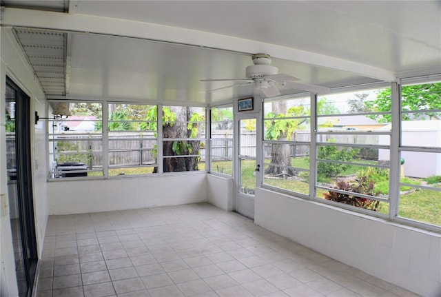 unfurnished sunroom featuring a ceiling fan