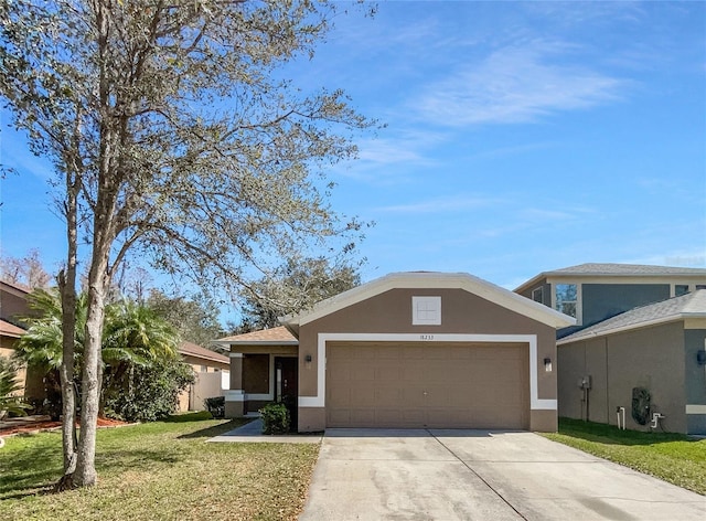 single story home with a garage, driveway, a front lawn, and stucco siding