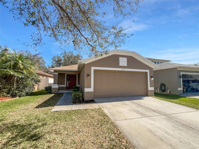 ranch-style house with a garage, a front yard, concrete driveway, and stucco siding