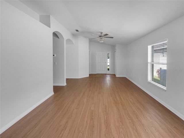 unfurnished living room with light wood-style floors, vaulted ceiling, and baseboards