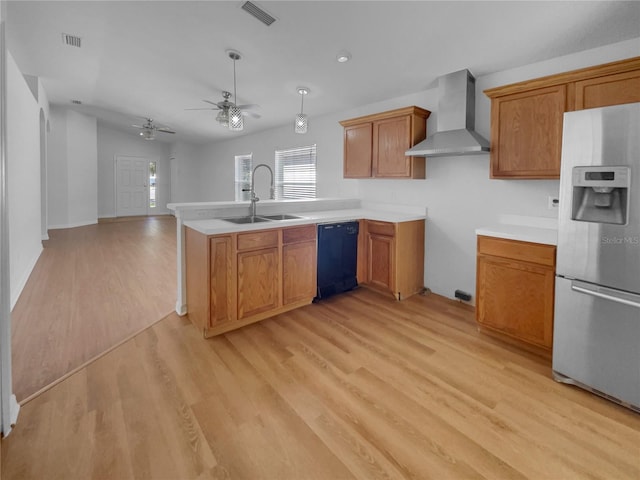 kitchen featuring stainless steel refrigerator with ice dispenser, light countertops, open floor plan, a sink, and wall chimney range hood