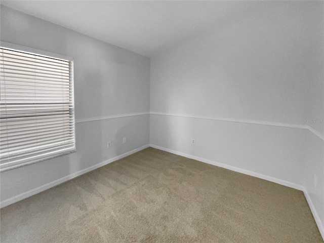 unfurnished room with carpet and baseboards