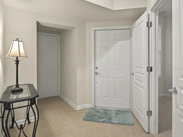 entrance foyer featuring light tile patterned flooring and baseboards