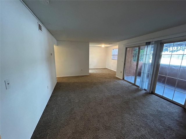 carpeted empty room with visible vents and baseboards