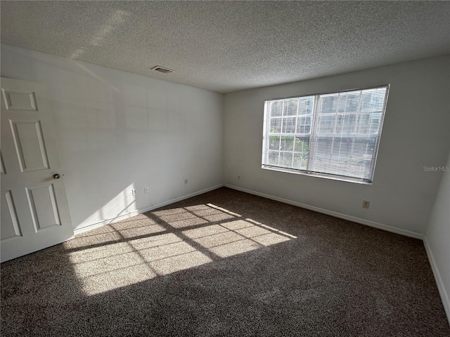 carpeted spare room featuring baseboards, visible vents, and a textured ceiling