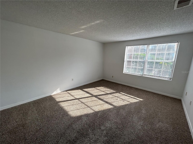 unfurnished room featuring carpet, visible vents, a textured ceiling, and baseboards