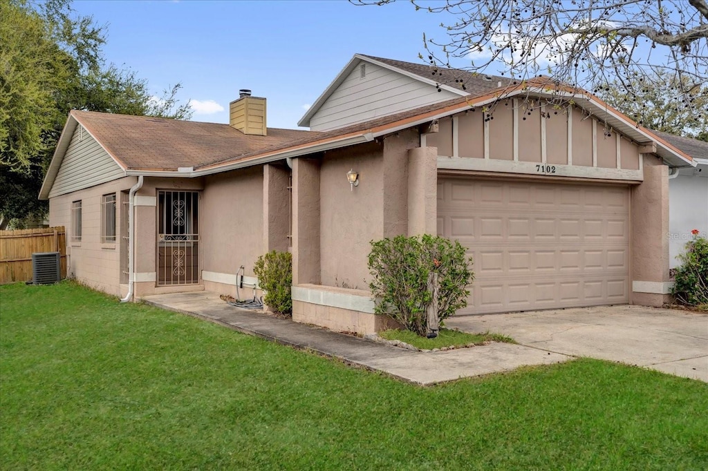 ranch-style home with central AC unit, an attached garage, fence, a front lawn, and a chimney