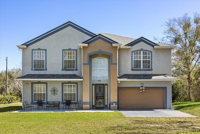 traditional home with a garage, a front yard, and stucco siding