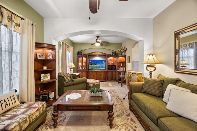 sitting room featuring ceiling fan and arched walkways