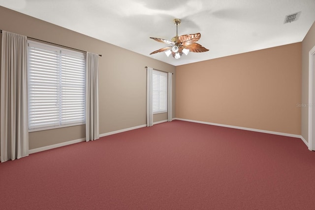 empty room featuring ceiling fan, carpet, visible vents, and baseboards