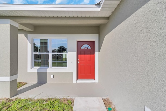 entrance to property featuring stucco siding