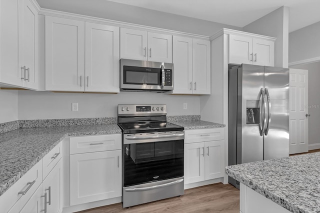 kitchen with appliances with stainless steel finishes, white cabinets, and light stone countertops