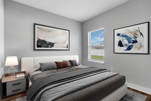 bedroom featuring baseboards and dark wood-type flooring