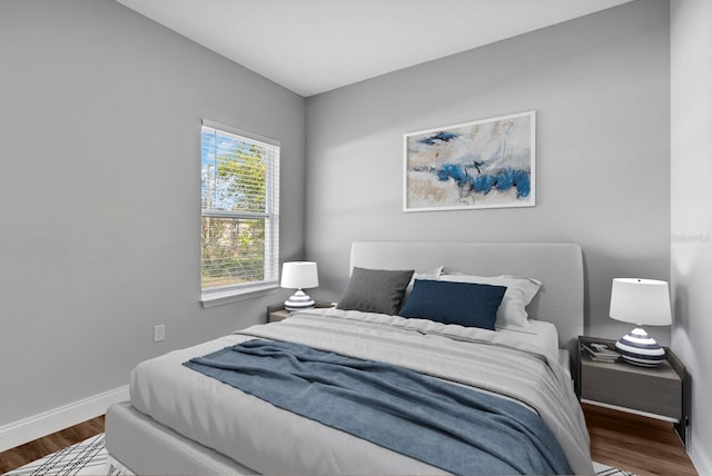 bedroom featuring dark wood-style flooring and baseboards