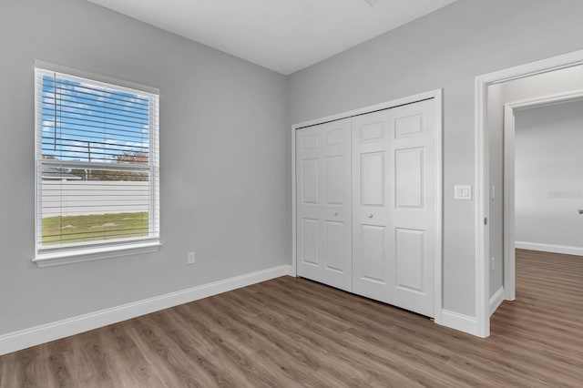 unfurnished bedroom with baseboards and wood finished floors