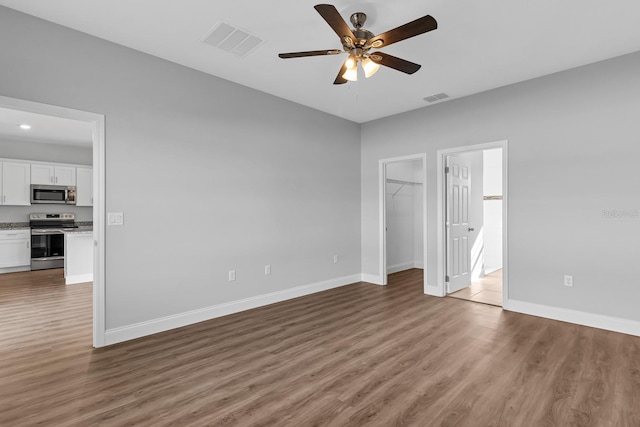 unfurnished bedroom with visible vents, baseboards, and wood finished floors