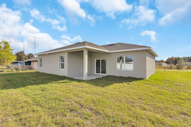 back of house featuring stucco siding, fence, a patio, and a yard