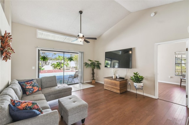 living room with a wealth of natural light, ceiling fan, baseboards, and wood finished floors