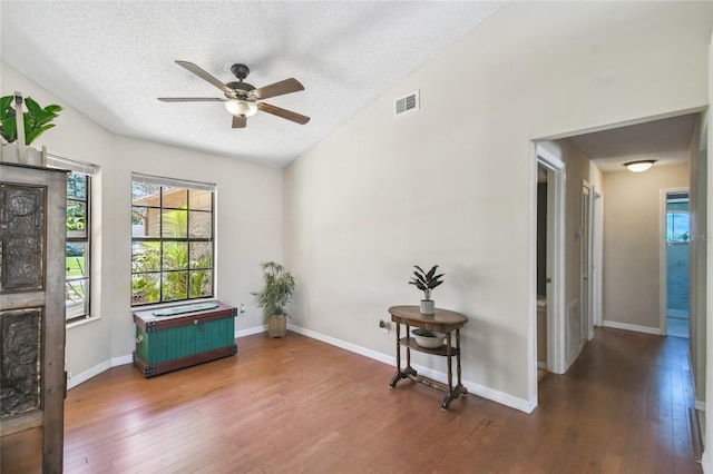 sitting room with visible vents, a ceiling fan, a textured ceiling, hardwood / wood-style floors, and baseboards