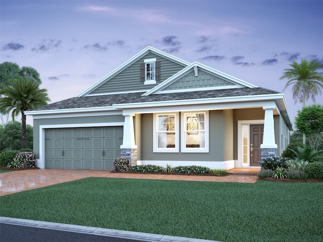 view of front of property with driveway, roof with shingles, an attached garage, a front lawn, and stucco siding