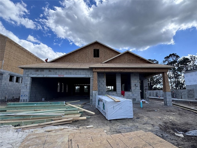 rear view of house featuring a garage and concrete block siding