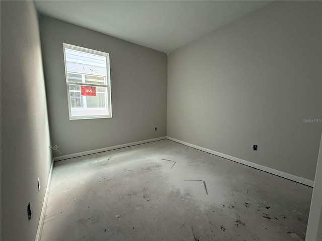 unfurnished room with unfinished concrete flooring and baseboards