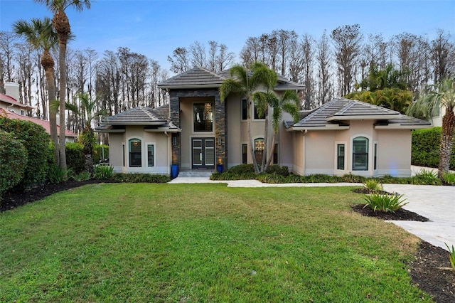 view of front of property with stone siding, a front lawn, and stucco siding