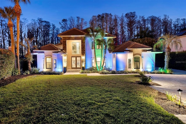 5524 Sail Ct, Orlando, FL 32819 - mediterranean / spanish house with stucco siding, a front lawn, a tile roof, and french doors