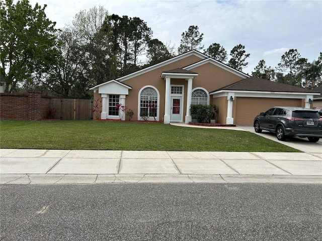 view of front of home featuring fence, a front yard, stucco siding, a garage, and driveway