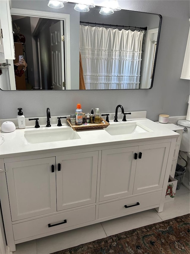 full bath with tile patterned flooring, double vanity, and a sink