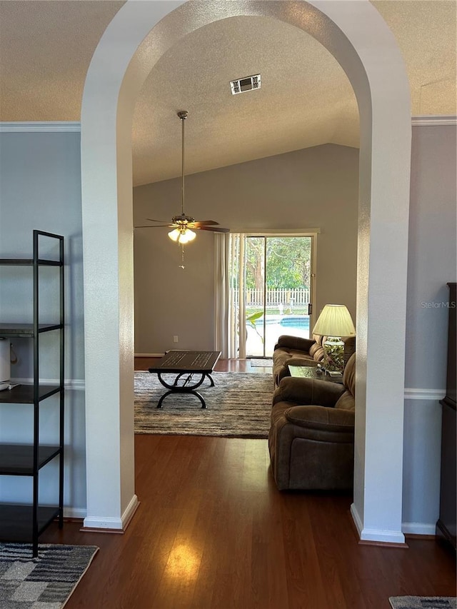 living area with vaulted ceiling, visible vents, a textured ceiling, and wood finished floors