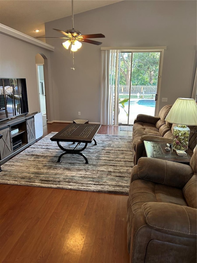 living area featuring arched walkways, a ceiling fan, lofted ceiling, and wood finished floors