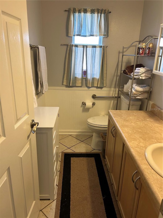 bathroom featuring tile patterned floors, a wainscoted wall, toilet, and vanity