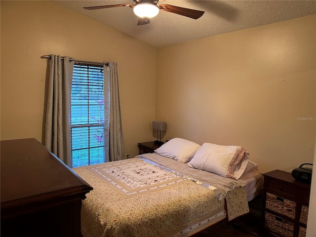 bedroom featuring ceiling fan, lofted ceiling, and a textured ceiling