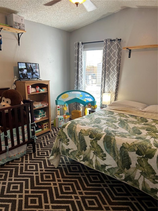 bedroom with a textured ceiling, a ceiling fan, carpet, and vaulted ceiling