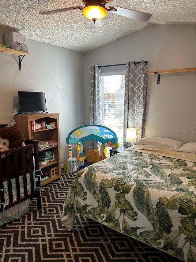 bedroom featuring lofted ceiling, carpet floors, and a textured ceiling