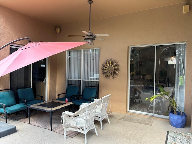 view of patio with an outdoor living space with a fire pit and ceiling fan