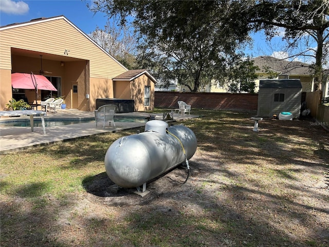 view of yard featuring a swimming pool, an outbuilding, a fenced backyard, and a shed