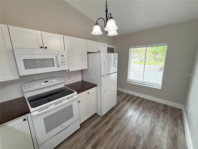 kitchen featuring white appliances, white cabinets, dark countertops, dark wood-type flooring, and hanging light fixtures