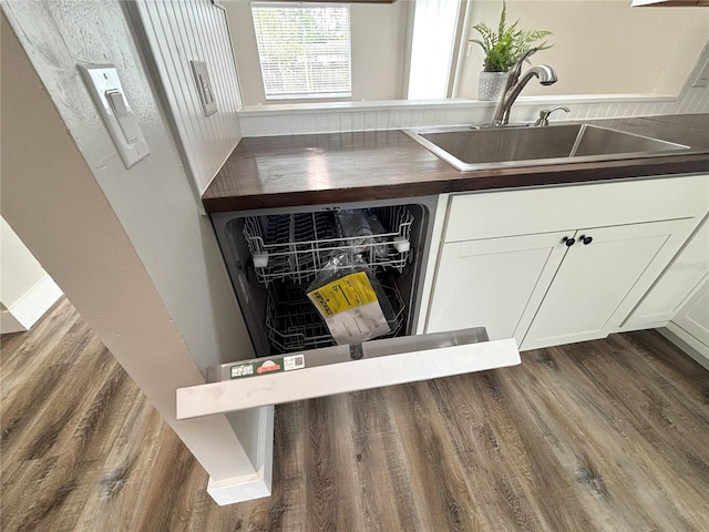 kitchen with a sink, dark wood finished floors, and white cabinets